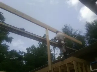 Carpenter setting a ridge beam over a new addition frame — Ice Dam Removal by Roofing Brothers in Jackson Heights